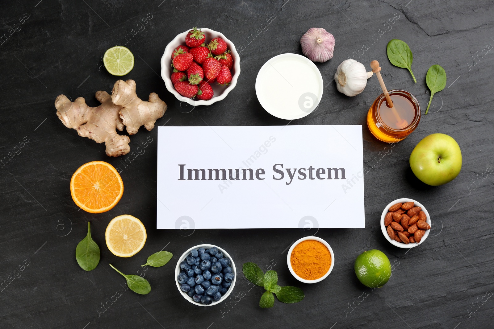 Photo of Card with phrase Immune System and fresh products on dark grey background, flat lay