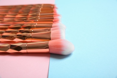 Photo of Set of professional makeup brushes on color background. Space for text