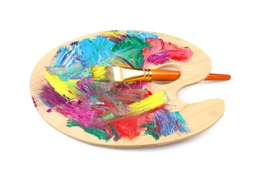 Photo of Wooden artist's palette with mixed paints and brush isolated on white