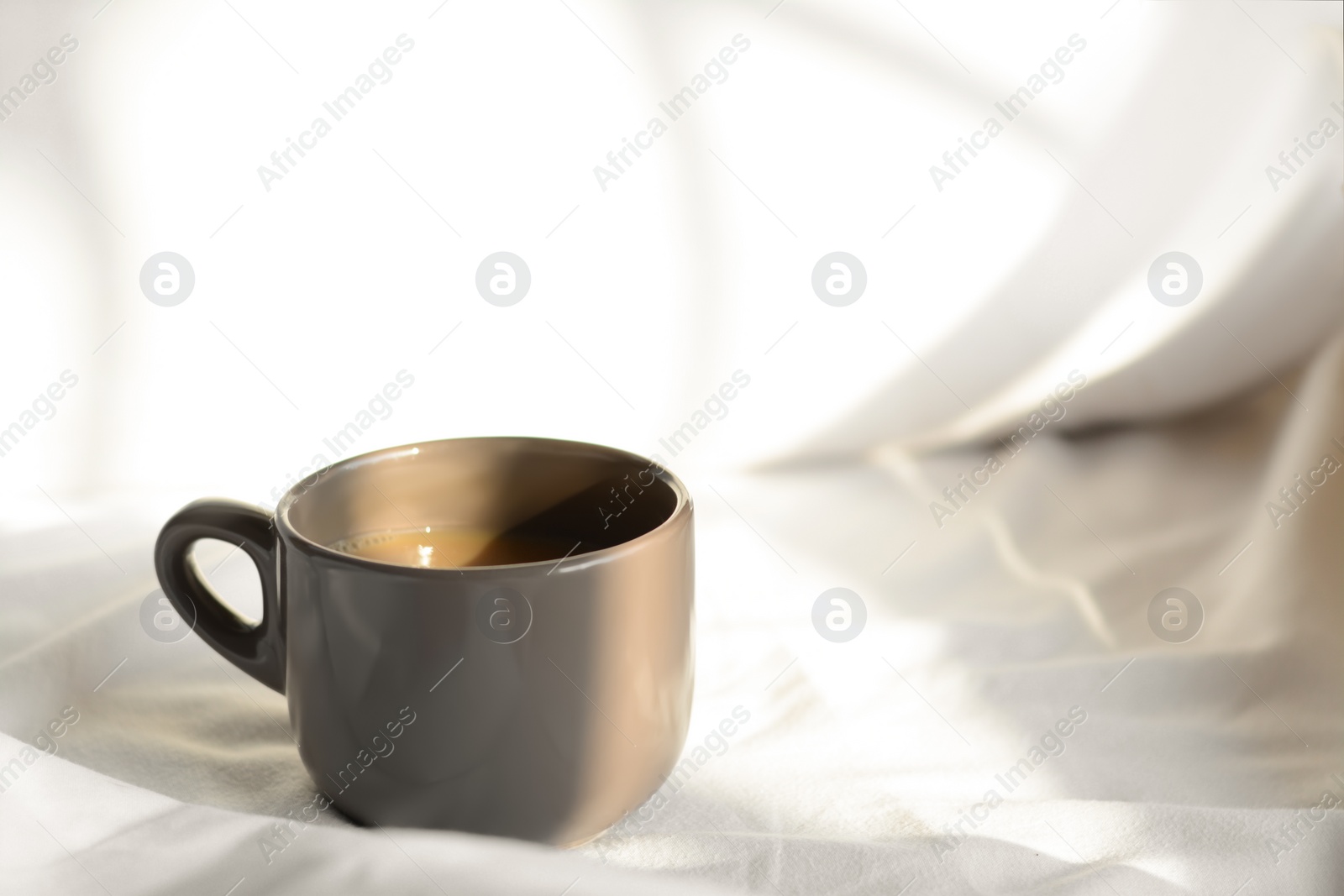 Photo of Aromatic morning coffee on bed, space for text