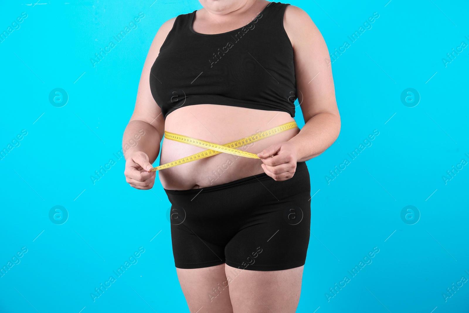 Photo of Fat woman with measuring tape on color background, closeup. Weight loss