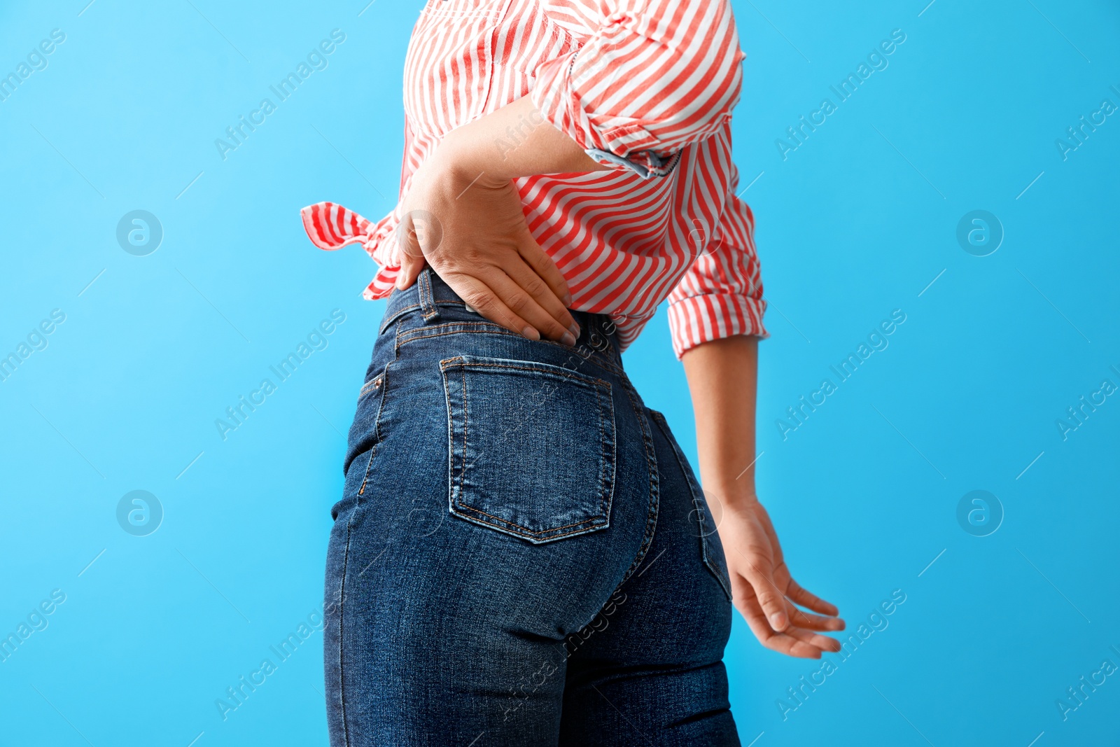 Photo of Woman wearing jeans on blue background, closeup