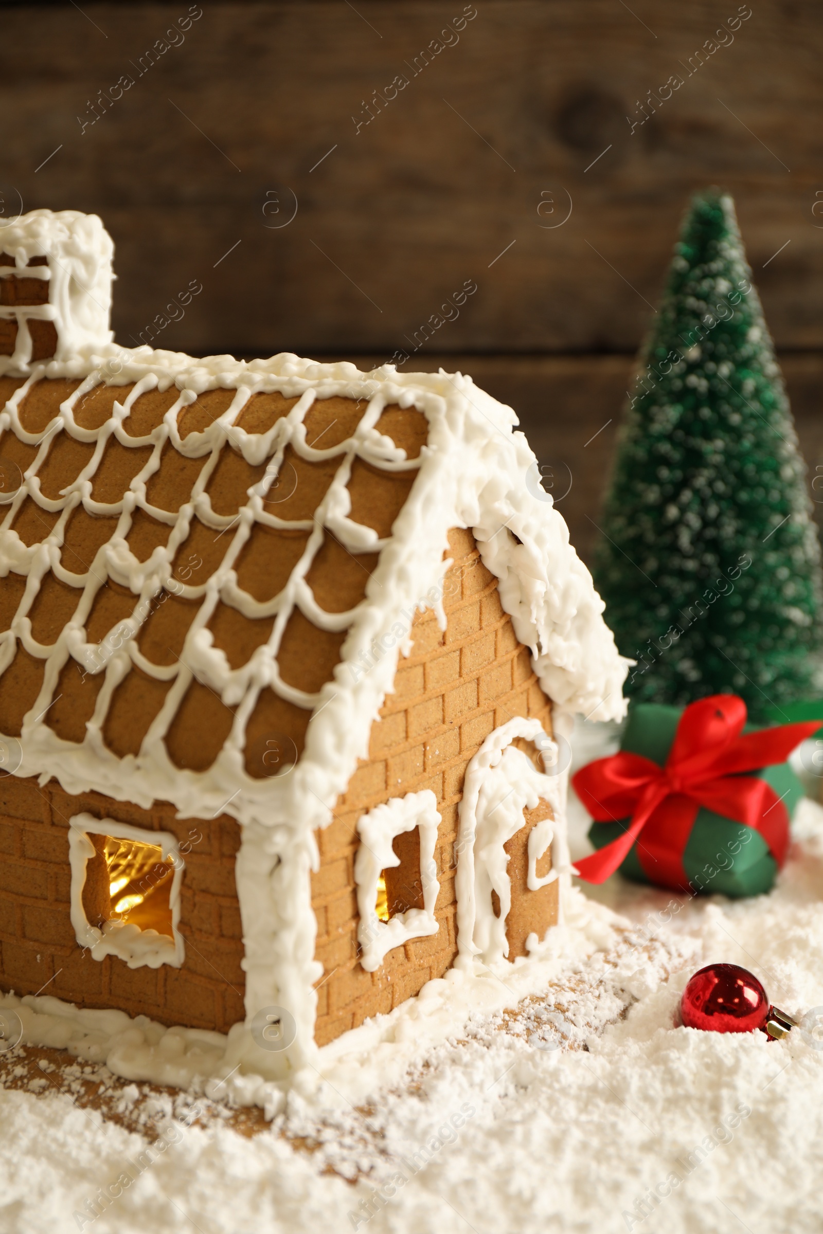 Photo of Beautiful gingerbread house decorated with icing on snow