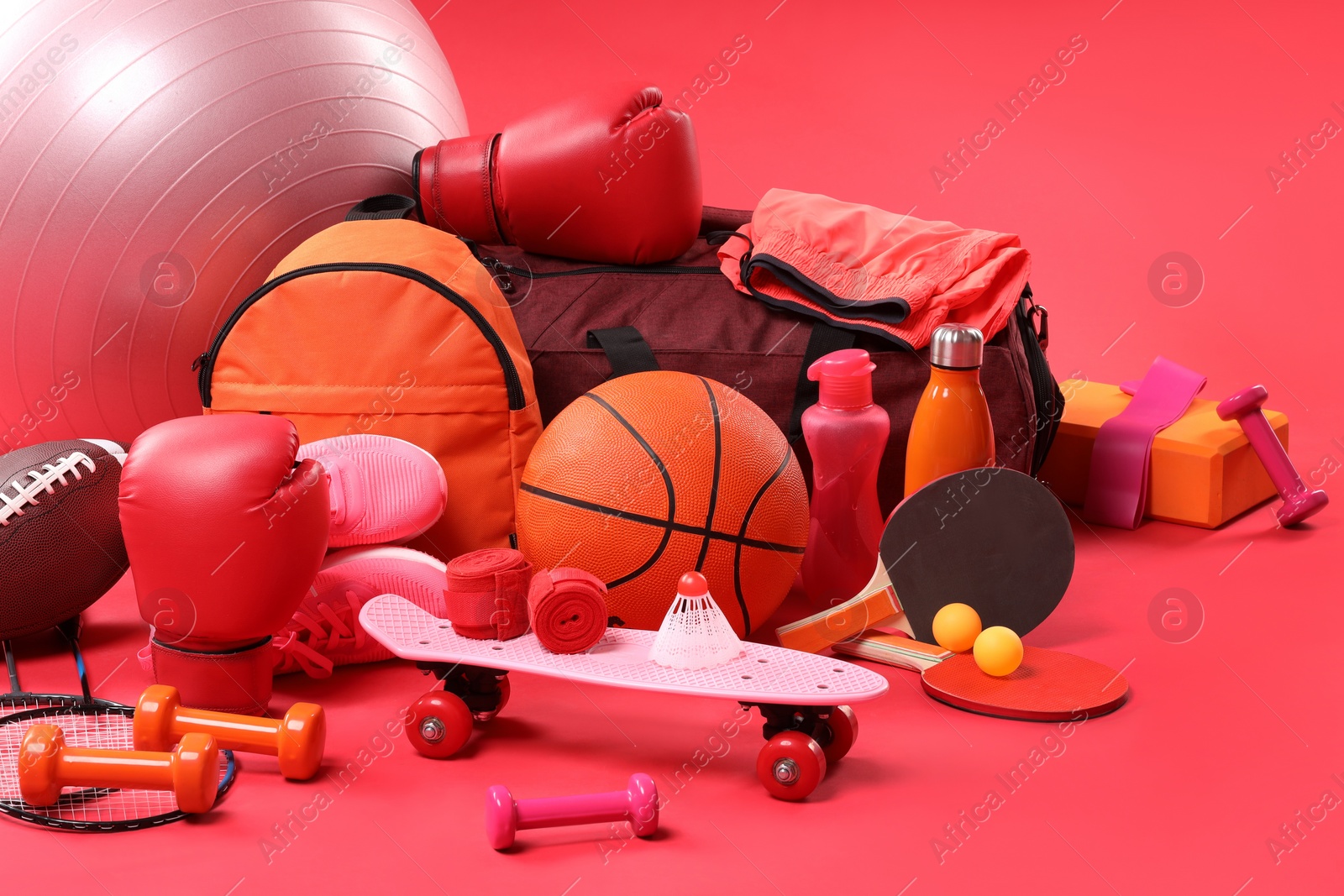 Photo of Many different sports equipment on red background