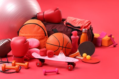 Photo of Many different sports equipment on red background