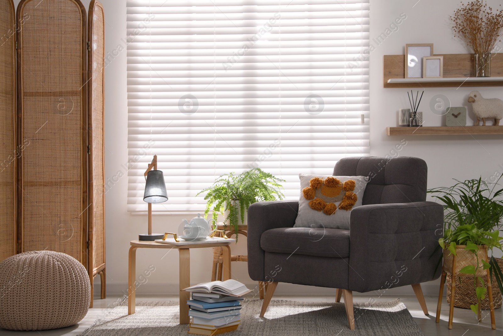 Photo of Comfortable place for rest with armchair near window in room