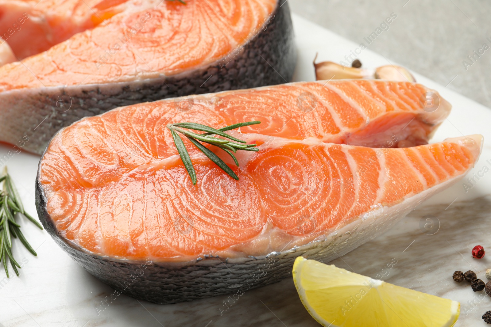 Photo of Fresh salmon and ingredients for marinade on marble board, closeup