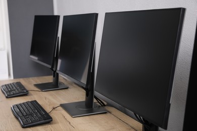 Open office interior. Modern workplaces with computers near light grey wall