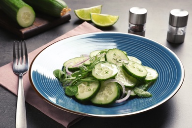 Photo of Plate with tasty cucumber salad served on  table