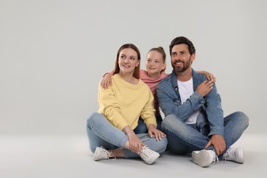 Happy family on light grey background, space for text