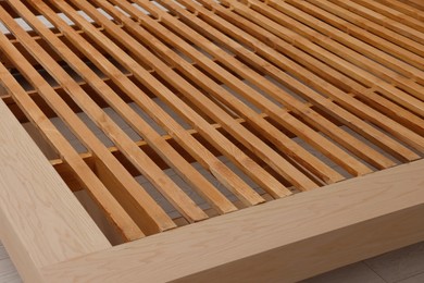 Photo of Closeup view of new wooden bed frame indoors