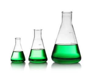 Photo of Conical flasks with green liquid on white background