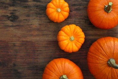 Photo of Fresh ripe pumpkins on wooden table, flat lay. Space for text