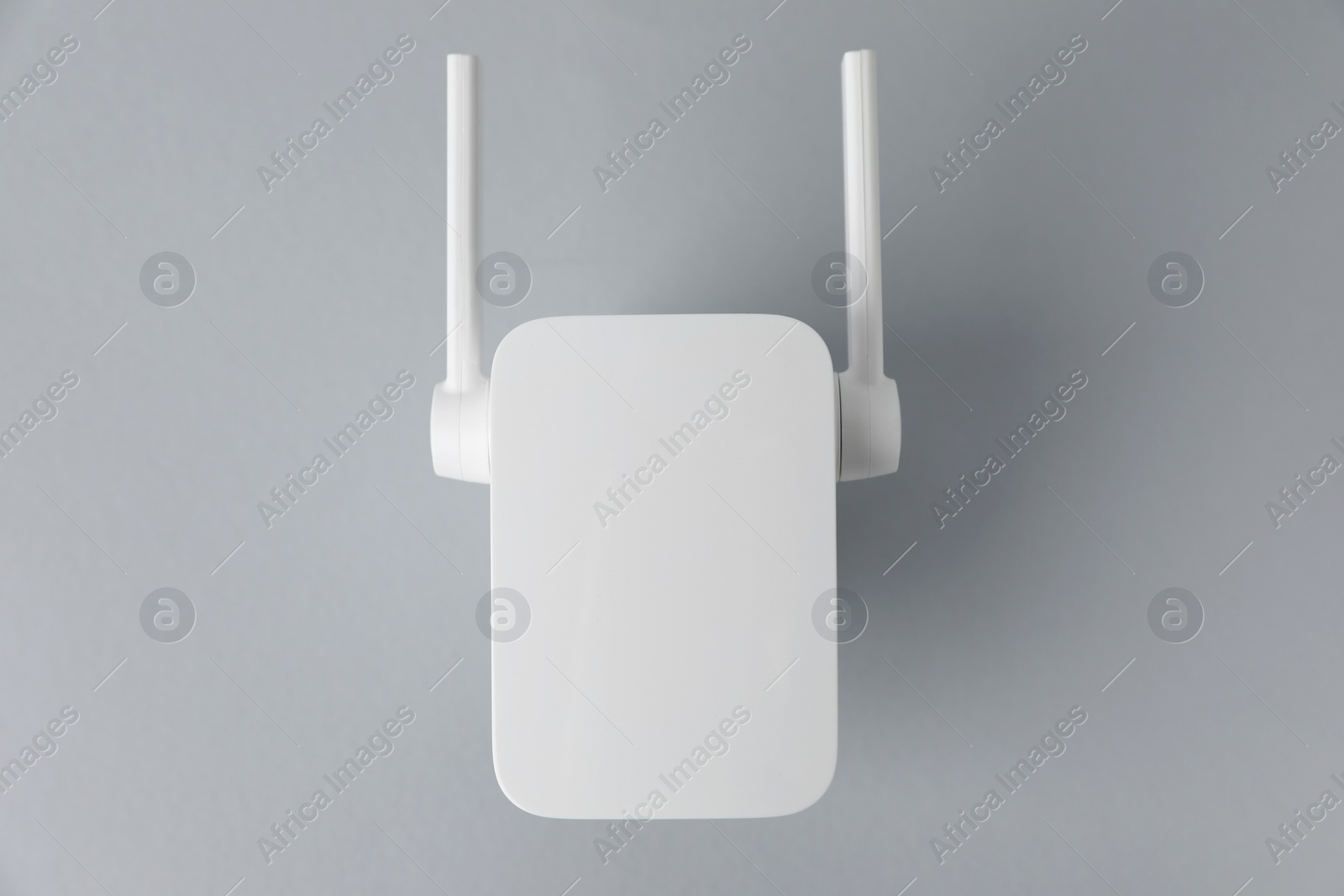 Photo of New modern Wi-Fi repeater on light gray background