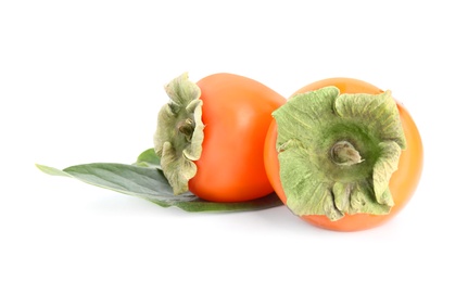 Photo of Delicious persimmons and green leaf isolated on white