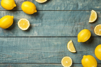 Photo of Flat lay composition with whole and sliced lemons on wooden background