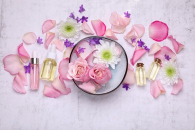 Flat lay composition with bowl of water and beautiful flowers on light table. Spa treatment