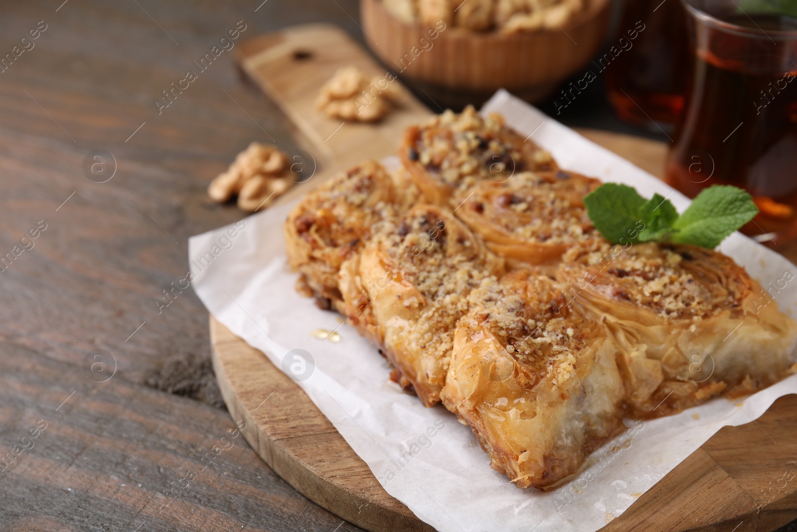 Photo of Eastern sweets. Pieces of tasty baklava on wooden table, closeup. Space for text