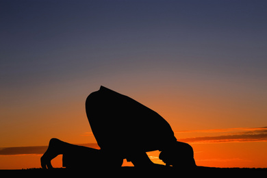 Image of Silhouette of Muslim man praying at sunset. Holy month of Ramadan