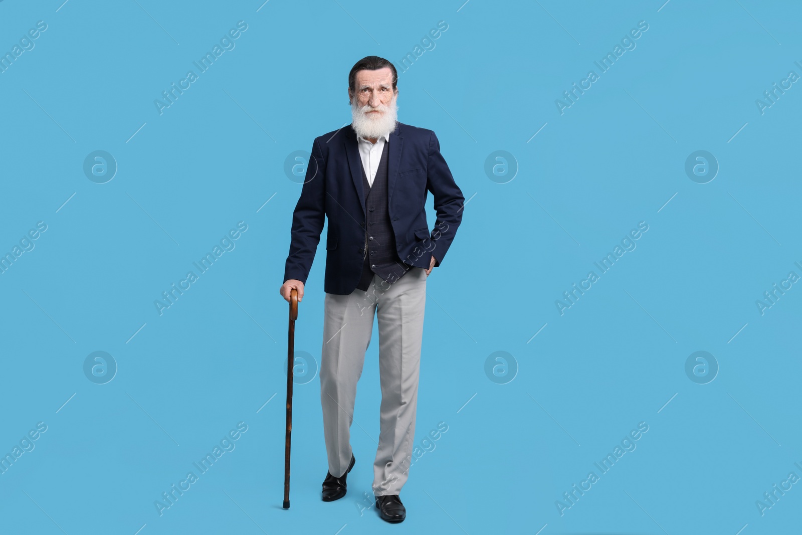 Photo of Senior man with walking cane on light blue background