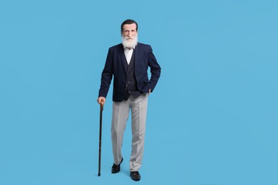 Photo of Senior man with walking cane on light blue background