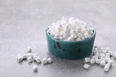 Photo of Bowl with delicious marshmallows on light gray background