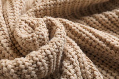 Beautiful beige knitted fabric as background, closeup