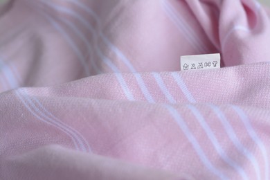 White clothing label on pale pink garment