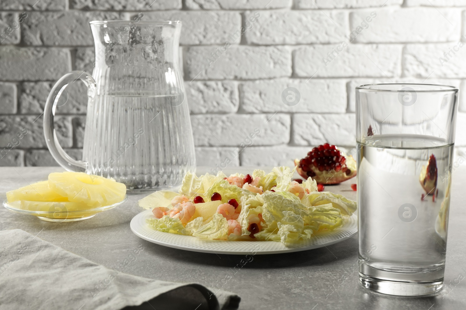 Photo of Delicious salad with Chinese cabbage, shrimps and pineapple served on grey table