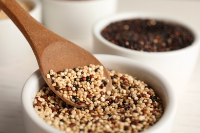 Photo of Spoon and bowl with mixed quinoa seeds, closeup