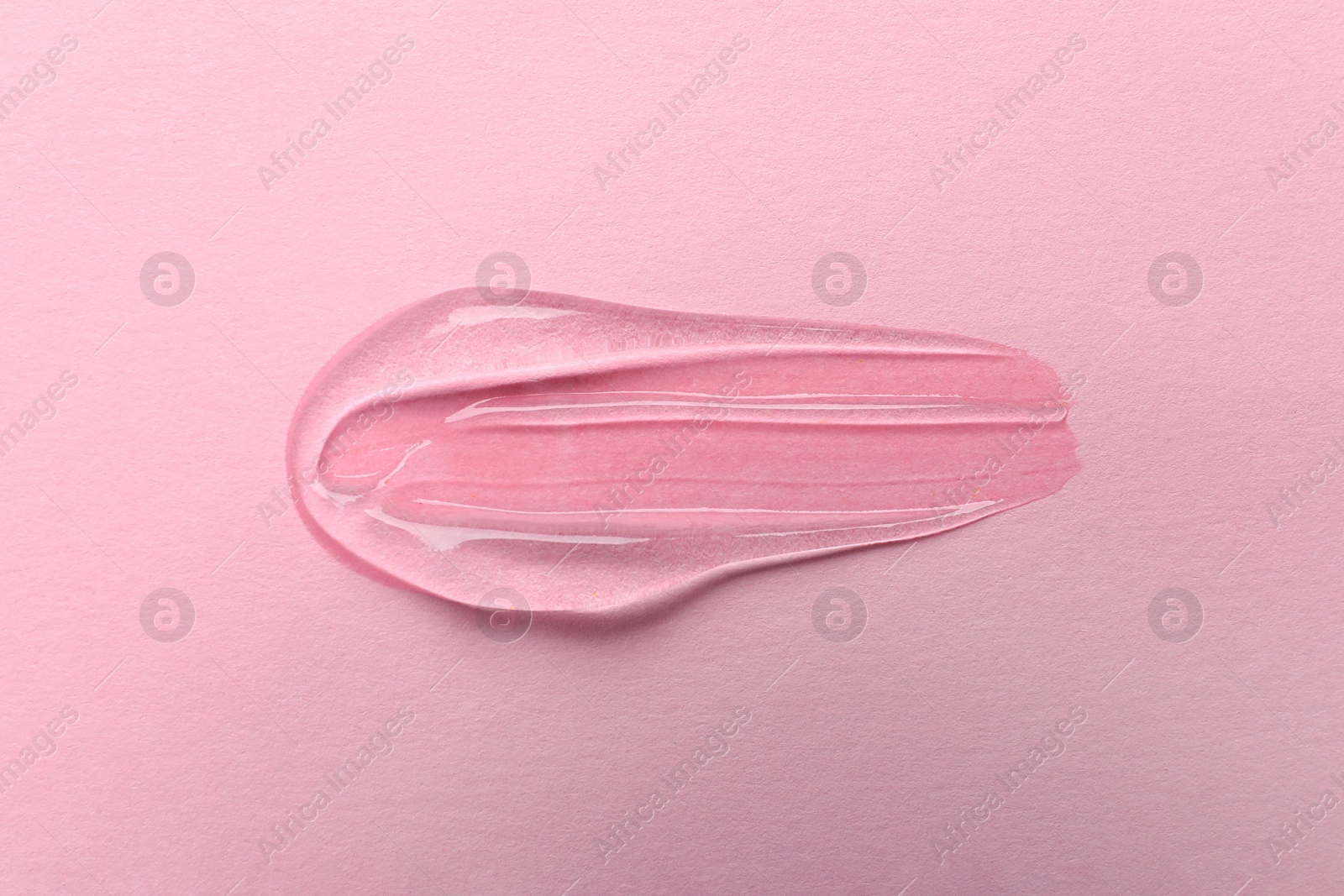 Photo of Sample of transparent gel on pink background, top view