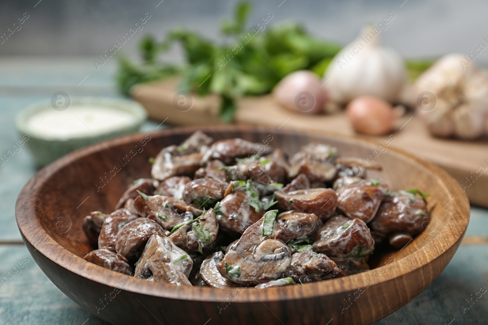 Photo of Bowl of fried mushrooms with sauce on table, closeup