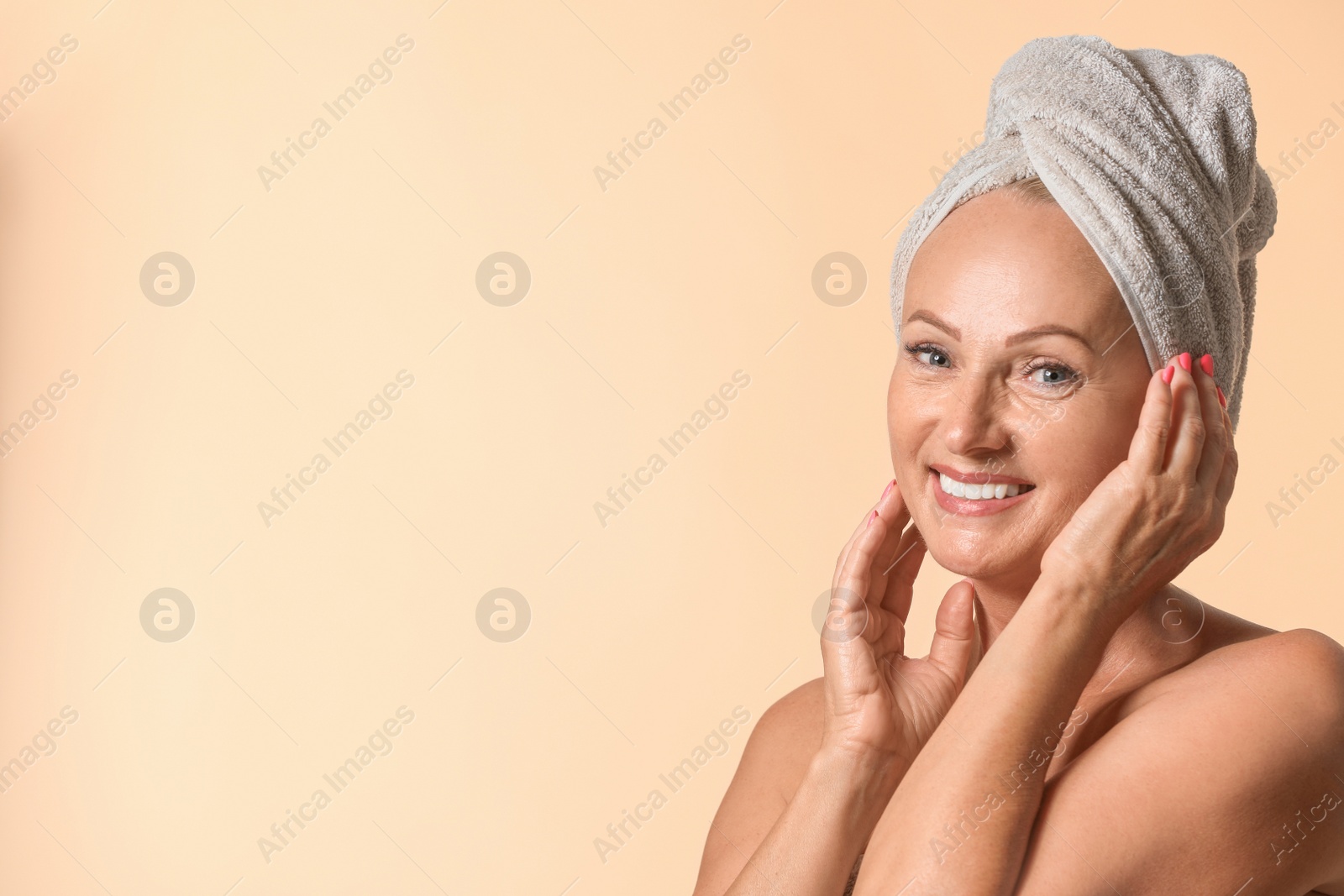 Photo of Portrait of beautiful mature woman with perfect skin on beige background. Space for text