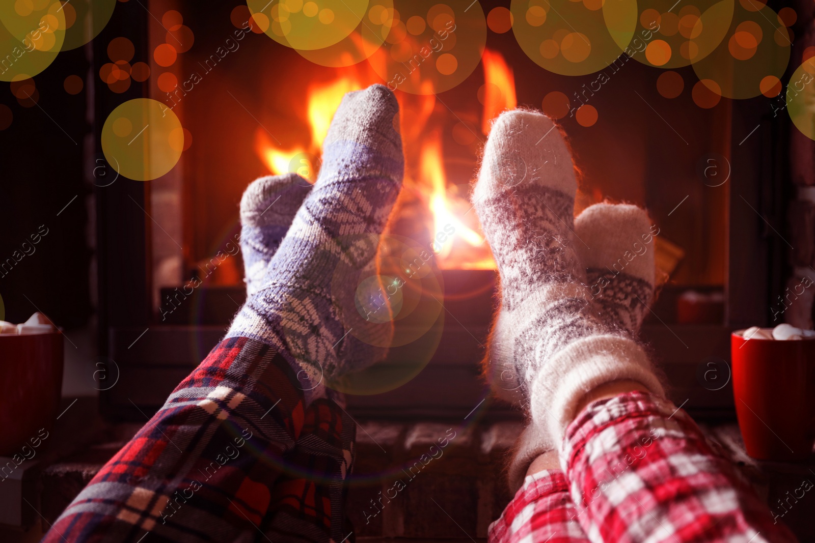 Image of Couple in pajamas resting near fireplace indoors, closeup. Winter vacation