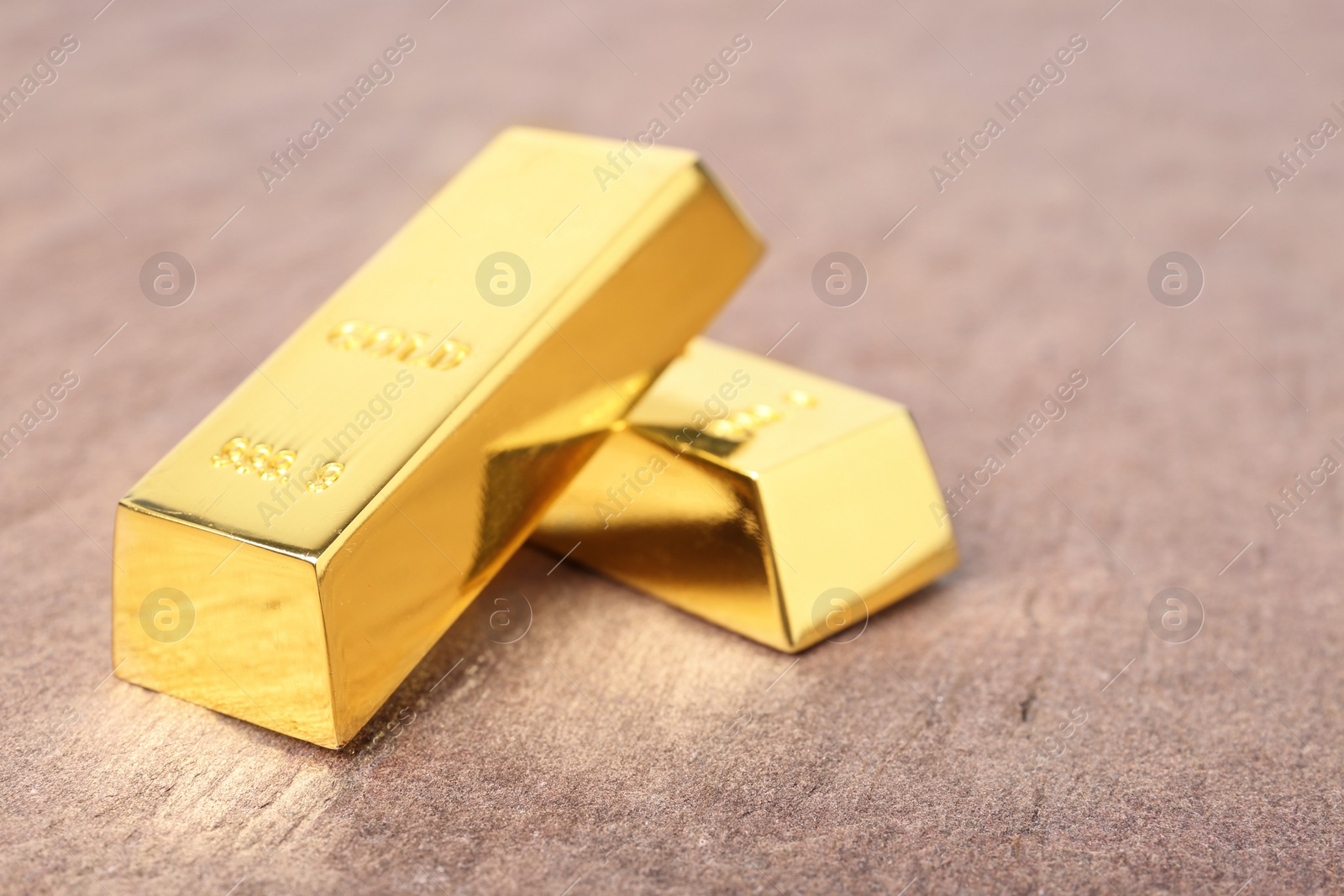 Photo of Shiny gold bars on table. Space for text