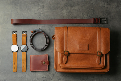 Photo of Flat lay composition with leather bag and accessories on grey stone table