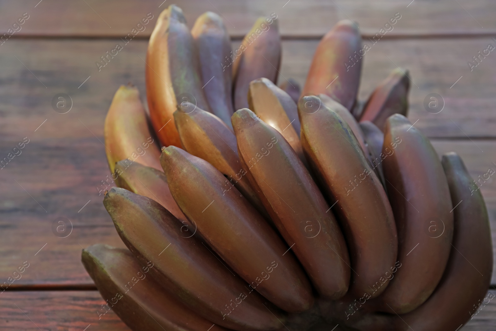 Photo of Tasty purple bananas on wooden table, closeup