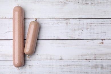 Photo of Delicious liver sausages on white wooden table, flat lay. Space for text