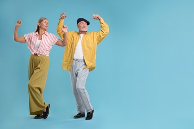 Photo of Senior couple dancing together on light blue background