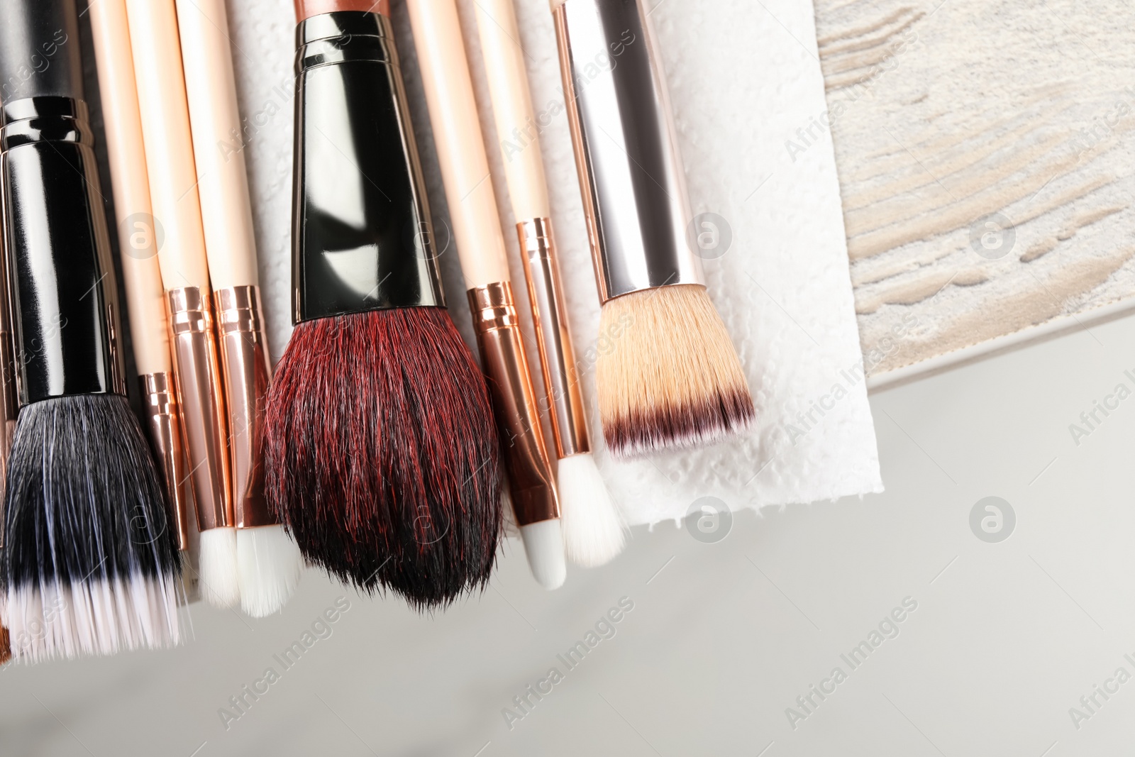 Photo of Set of different makeup brushes drying after cleaning on table, closeup