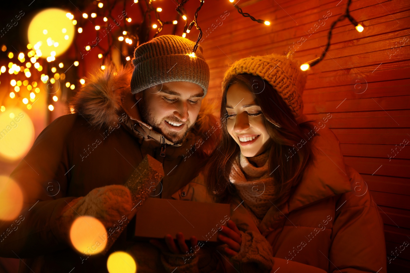 Photo of Happy couple with gift box at Christmas fair