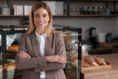 Photo of Happy business owner in bakery shop. Space for text