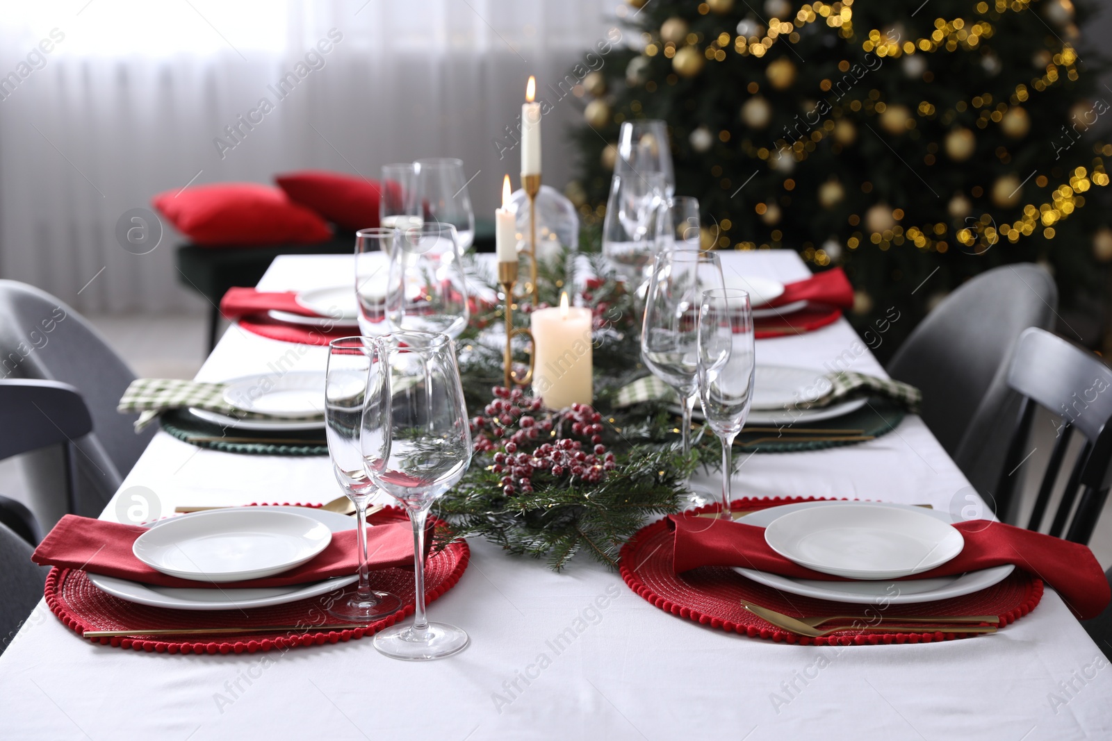 Photo of Christmas table setting with festive decor and dishware indoors