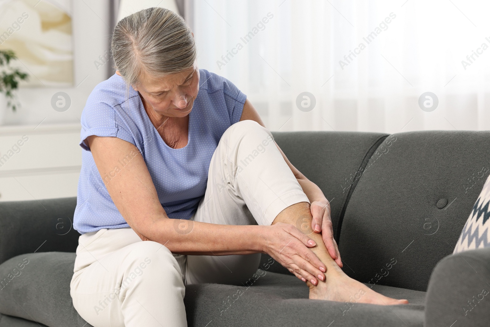 Photo of Arthritis symptoms. Woman suffering from pain in leg at home