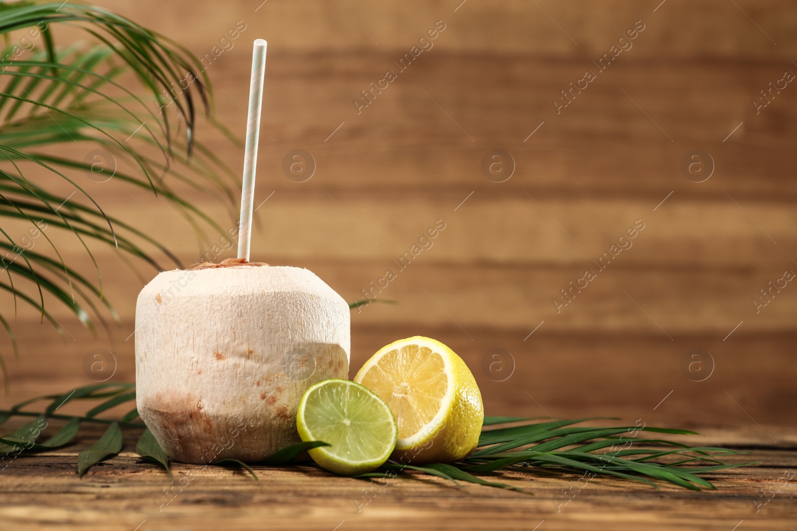 Photo of Open fresh coconut and citrus fruits on wooden table. Space for text