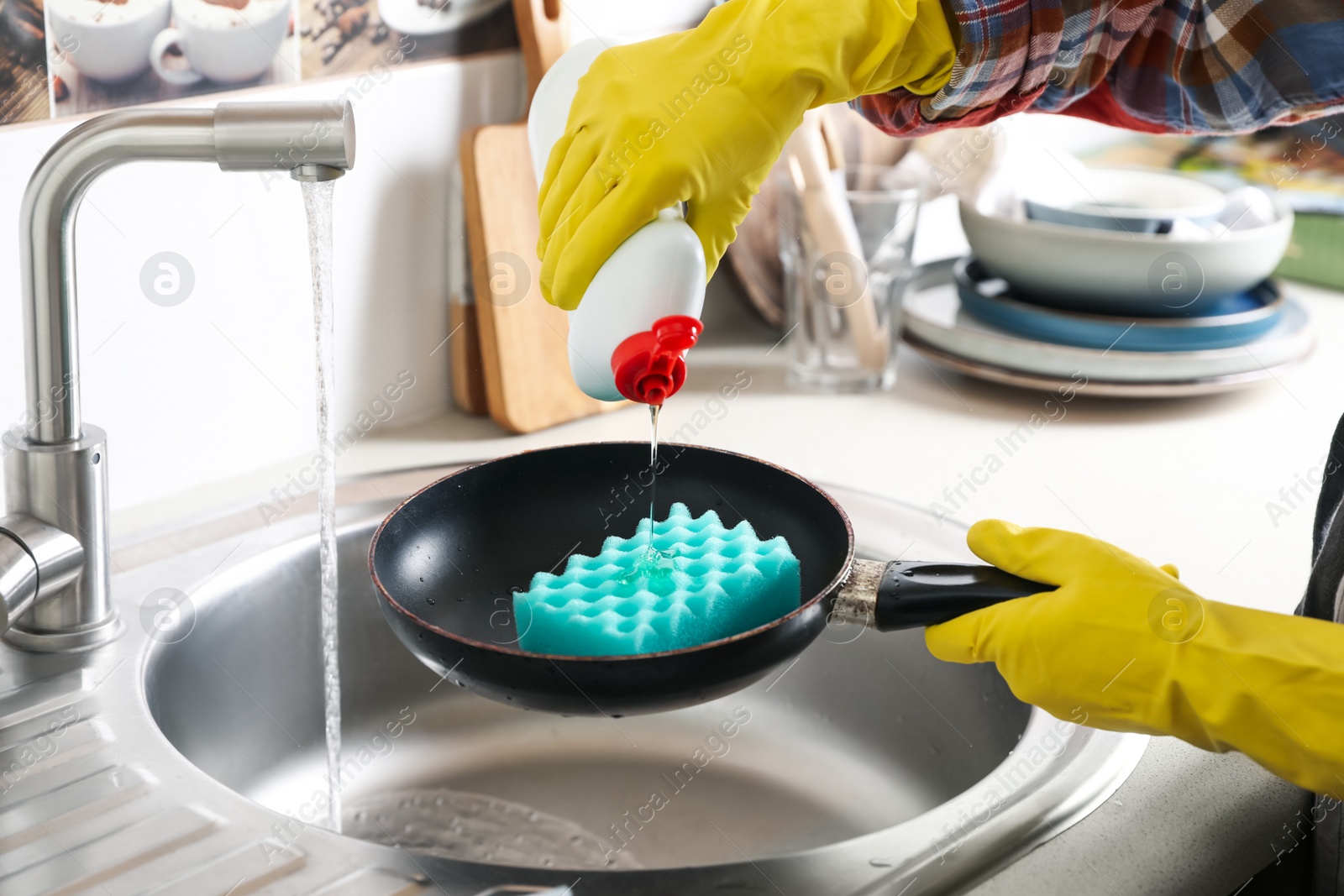 Photo of Woman using cleaning product for washing frying pan in sink indoors, closeup