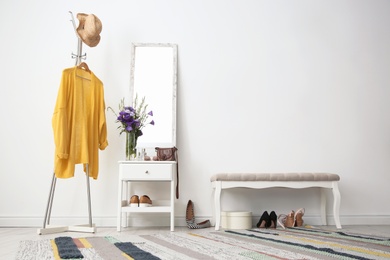 Stylish hallway interior with mirror and rack