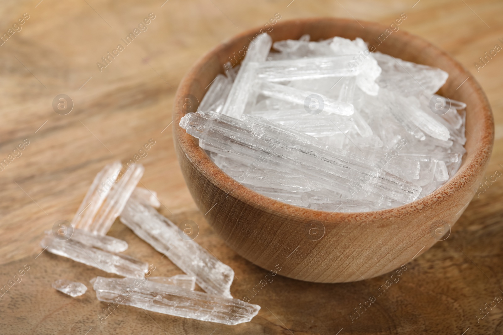 Photo of Menthol crystals in bowl on wooden background