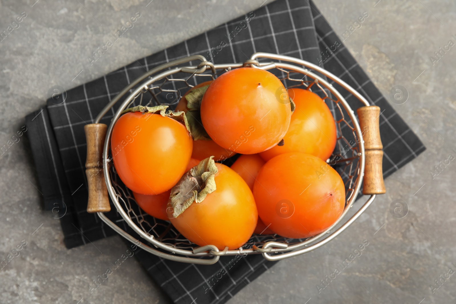 Photo of Delicious fresh persimmons on grey table, flat lay