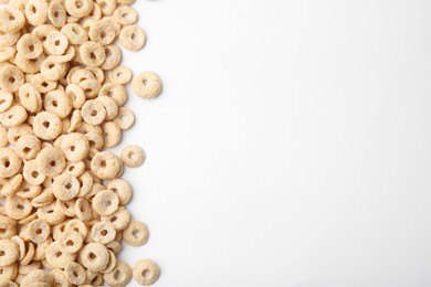 Photo of Tasty cereal rings on white background, flat lay. Space for text